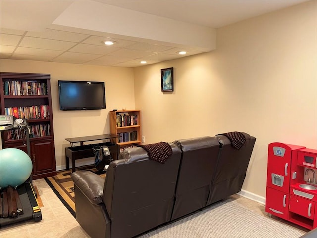 living area featuring baseboards, a paneled ceiling, and recessed lighting