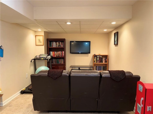 living room featuring a paneled ceiling, baseboards, and recessed lighting