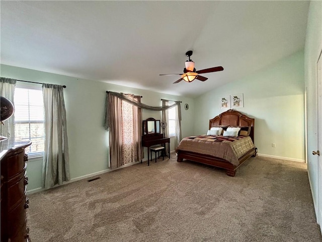 carpeted bedroom with baseboards, ceiling fan, visible vents, and vaulted ceiling