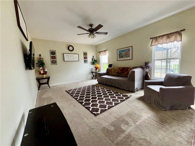 carpeted living room with baseboards and ceiling fan