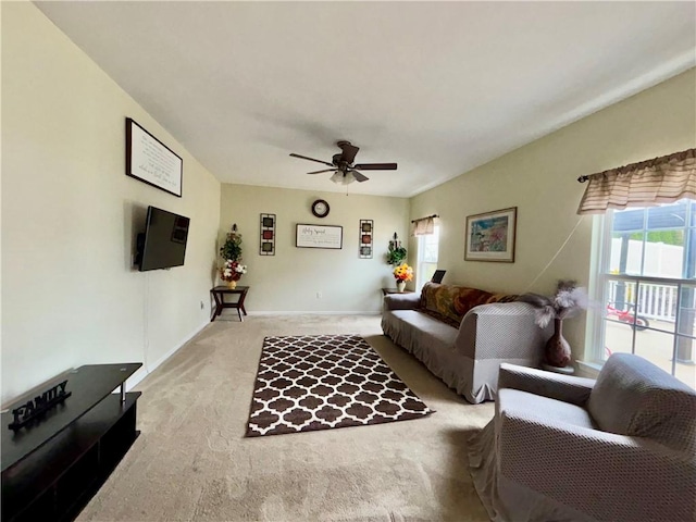 living room featuring light carpet, baseboards, and a ceiling fan