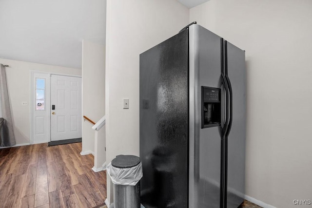 kitchen featuring stainless steel refrigerator with ice dispenser, wood finished floors, and baseboards