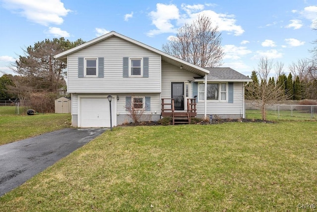 split level home with driveway, a garage, and a storage shed