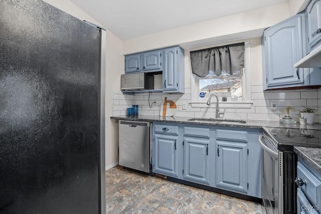 kitchen with a sink, stainless steel appliances, blue cabinetry, and decorative backsplash