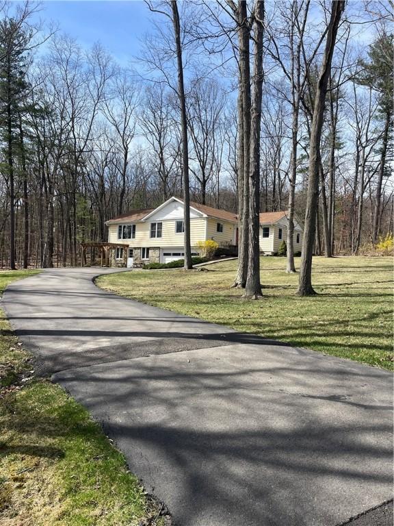 view of front of home with a front yard and aphalt driveway