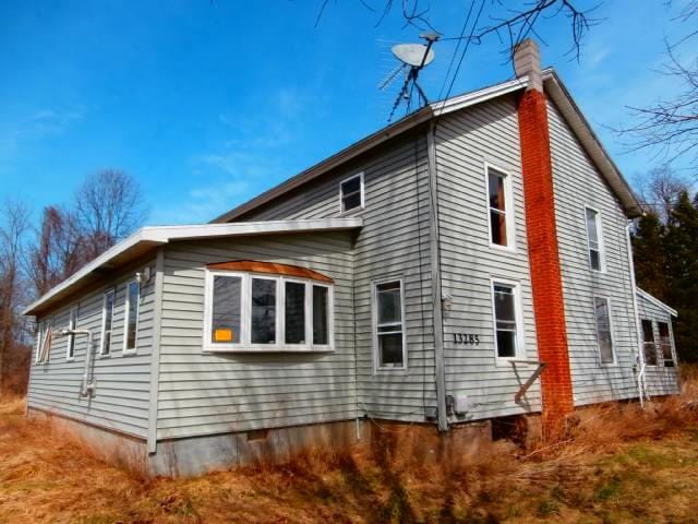 rear view of house featuring a chimney