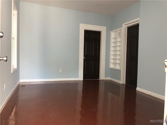 202 Thompson St, Buffalo, NY 14207 - spare room with baseboards, built in features, and wood finished floors