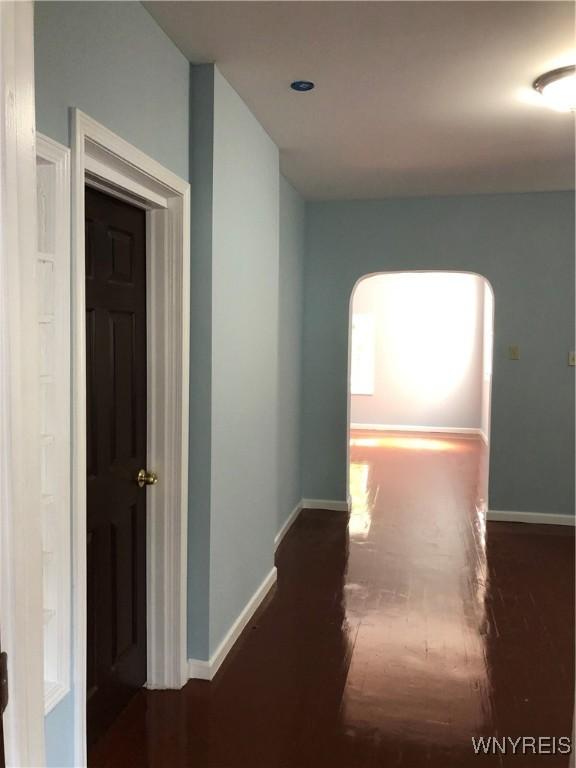 202 Thompson St, Buffalo, NY 14207 - hall featuring wood finished floors, baseboards, and arched walkways