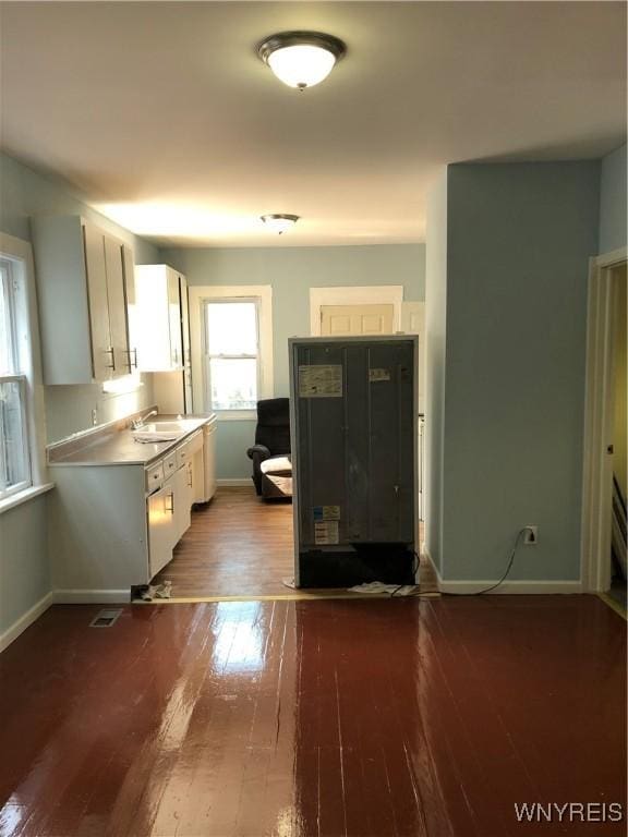 202 Thompson St, Buffalo, NY 14207 - kitchen featuring dark wood finished floors, baseboards, a sink, white cabinetry, and light countertops