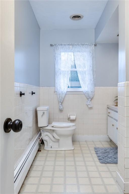 31 Briarcliff Dr, Horseheads, NY 14845 - bathroom with a baseboard radiator, wainscoting, tile walls, toilet, and visible vents