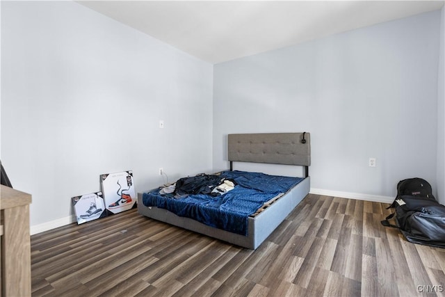 bedroom featuring baseboards and wood finished floors