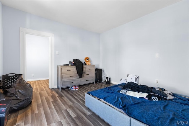 bedroom with baseboards and wood finished floors