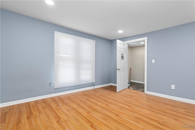 empty room with baseboards, light wood-type flooring, and recessed lighting