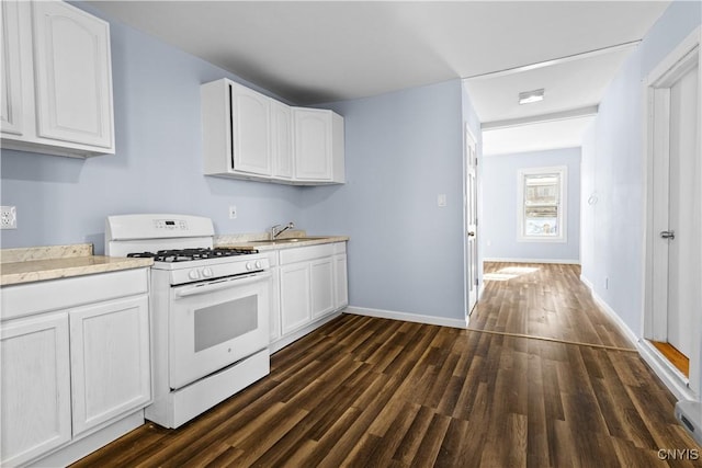 kitchen featuring white cabinetry, white gas range, dark wood-type flooring, baseboards, and a sink