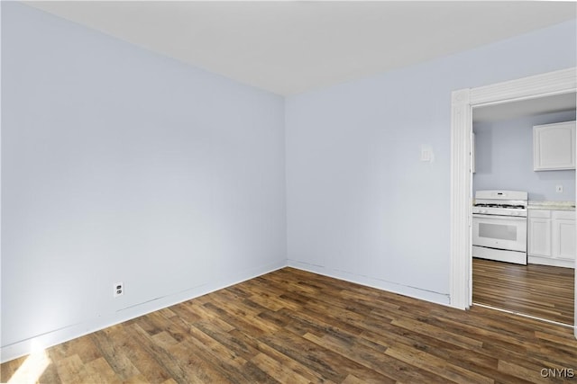 empty room with dark wood-style flooring and baseboards