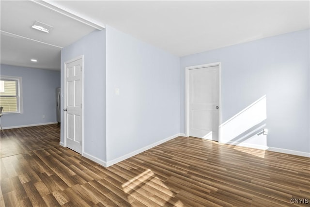 unfurnished room featuring dark wood-style floors and baseboards