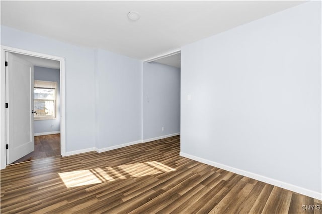 unfurnished room with baseboards and wood finished floors