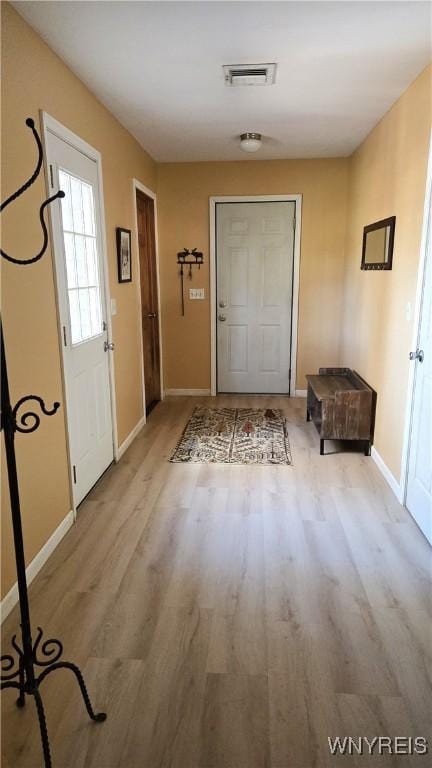 entryway with wood finished floors, visible vents, and baseboards