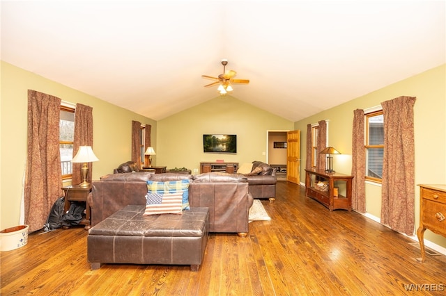 living room featuring vaulted ceiling, a ceiling fan, and wood finished floors