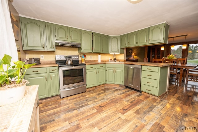 kitchen with under cabinet range hood, green cabinetry, appliances with stainless steel finishes, and light wood-style flooring