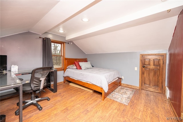 bedroom with baseboards, vaulted ceiling, and wood finished floors