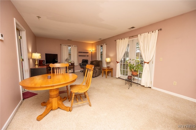 dining room featuring carpet floors, visible vents, and baseboards