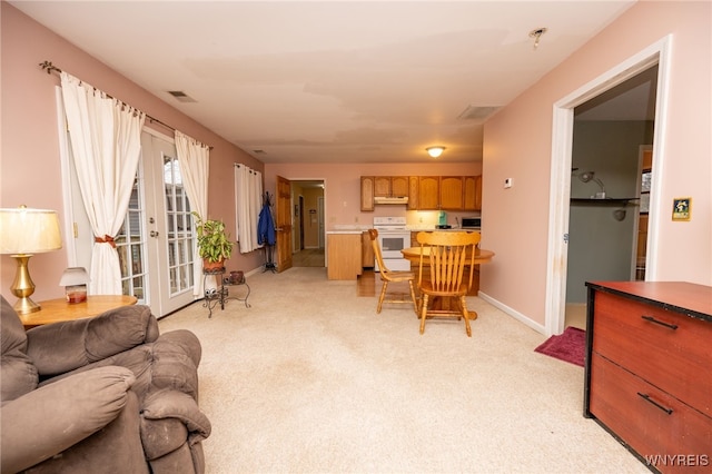 living area with light carpet, baseboards, and visible vents