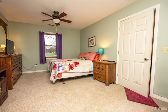 bedroom with ceiling fan, visible vents, baseboards, and light carpet