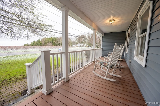 deck with a lawn and covered porch
