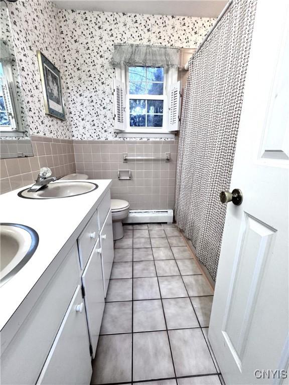 14 Barley Mow Run, New Hartford, NY 13413 - bathroom with tile patterned floors, toilet, a sink, baseboard heating, and tile walls