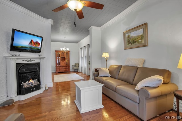 2831 S Park Ave, Lackawanna, NY 14218 - living room with ceiling fan with notable chandelier, crown molding, a warm lit fireplace, and wood finished floors