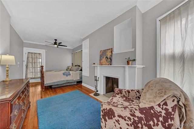 bedroom featuring hardwood / wood-style flooring, ornamental molding, ceiling fan, and baseboards