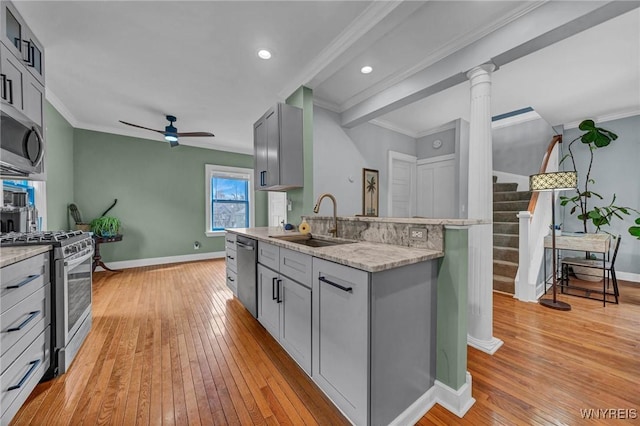 kitchen with a sink, stainless steel appliances, gray cabinets, a ceiling fan, and ornamental molding