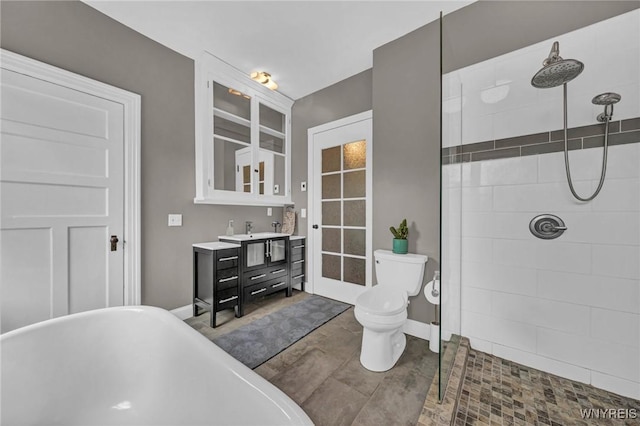 bathroom featuring a tile shower, baseboards, a freestanding tub, and toilet
