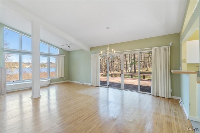 3158 W Lake Rd, Cazenovia, NY 13035 - unfurnished dining area featuring baseboards, a notable chandelier, lofted ceiling with beams, a water view, and light wood-style flooring