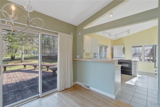 3158 W Lake Rd, Cazenovia, NY 13035 - kitchen with white cabinets, visible vents, a chandelier, lofted ceiling, and black gas range