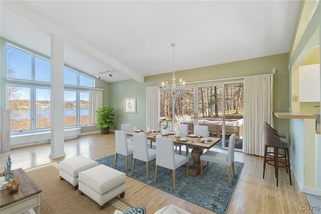 3158 W Lake Rd, Cazenovia, NY 13035 - dining room featuring lofted ceiling with beams, wood finished floors, a notable chandelier, and baseboards