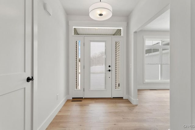 entryway with light wood-style floors and baseboards