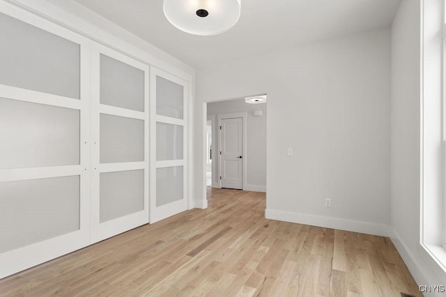empty room with baseboards and light wood-style flooring