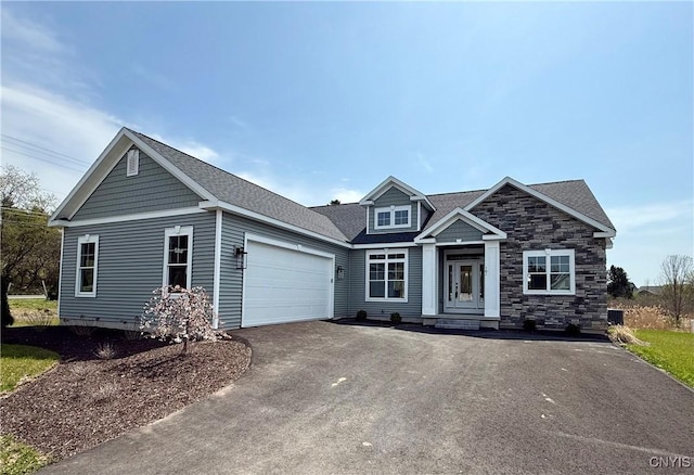 craftsman-style home with a garage, aphalt driveway, and stone siding