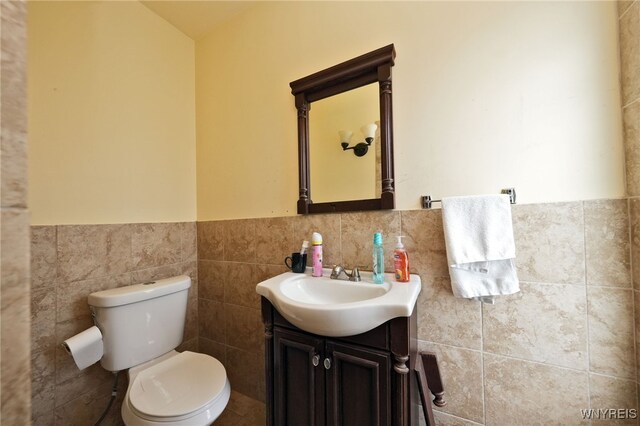 894 Tonawanda St, Buffalo, NY 14207 - half bath featuring vanity, a wainscoted wall, tile walls, and toilet
