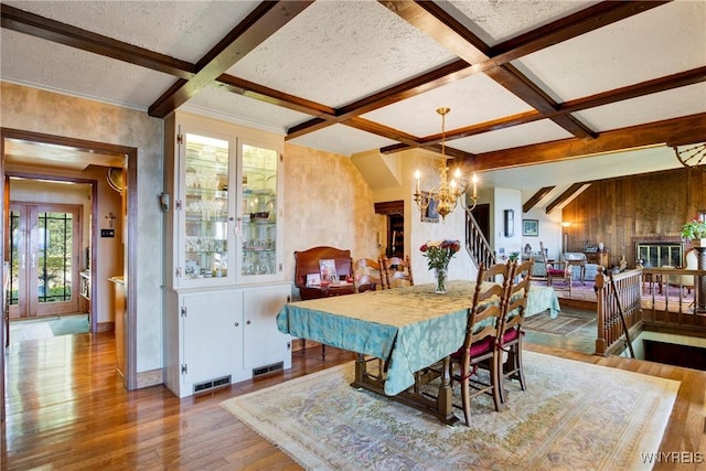 6634 Lake Shore Rd, Evans, NY 14047 - dining space featuring wood finished floors, stairs, beamed ceiling, a chandelier, and coffered ceiling