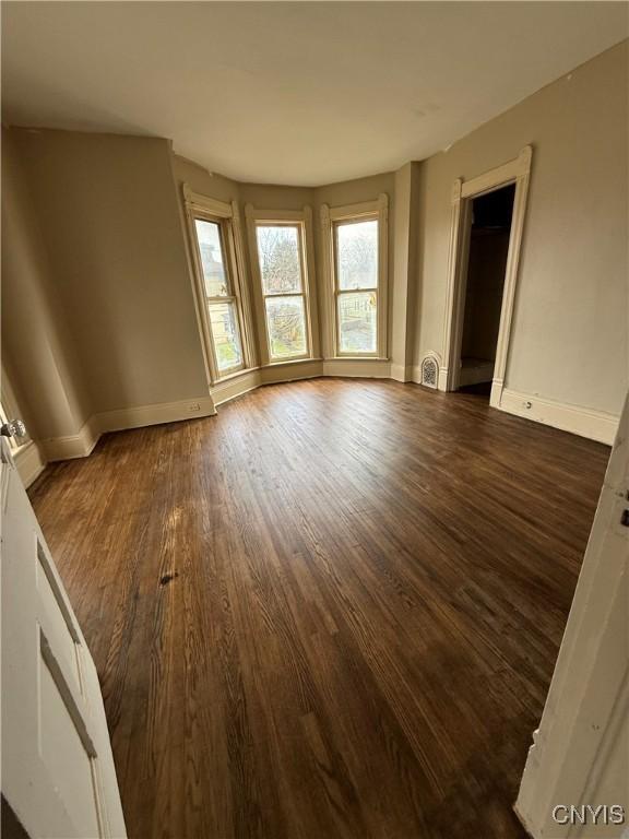 620 Court St, Syracuse, NY 13208 - spare room featuring dark wood-type flooring and baseboards