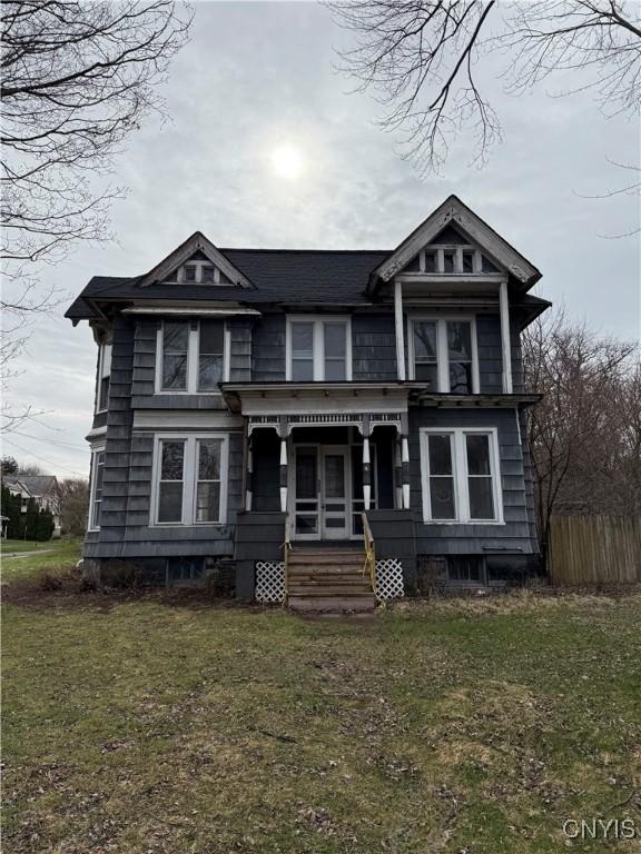 620 Court St, Syracuse, NY 13208 - victorian house featuring covered porch, a front yard, and fence