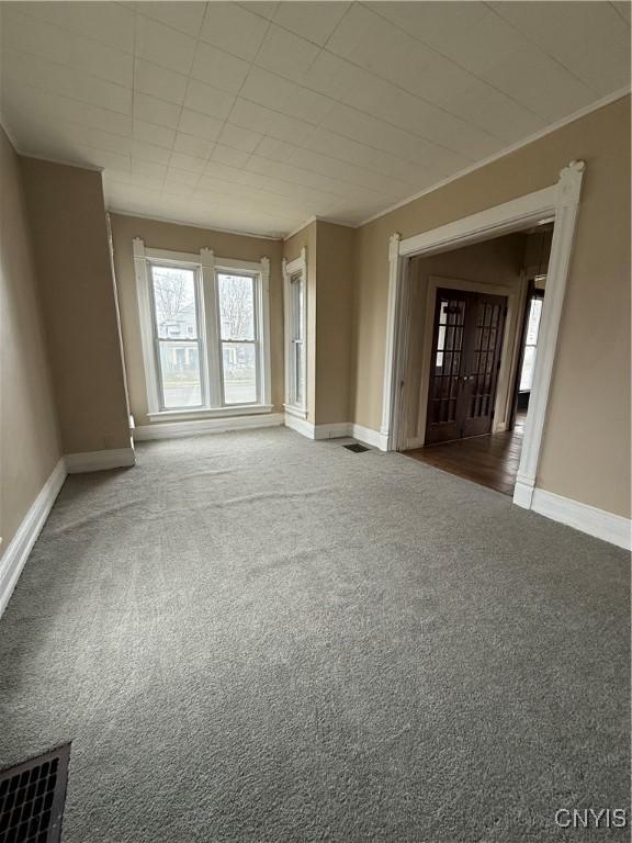 620 Court St, Syracuse, NY 13208 - carpeted empty room with visible vents, baseboards, and ornamental molding