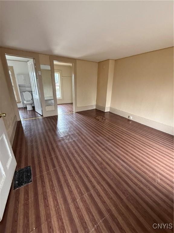 620 Court St, Syracuse, NY 13208 - unfurnished living room with dark wood-style flooring, baseboards, and visible vents