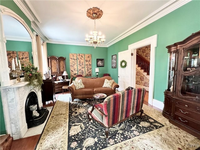 living area featuring crown molding, an inviting chandelier, decorative columns, a high end fireplace, and baseboards