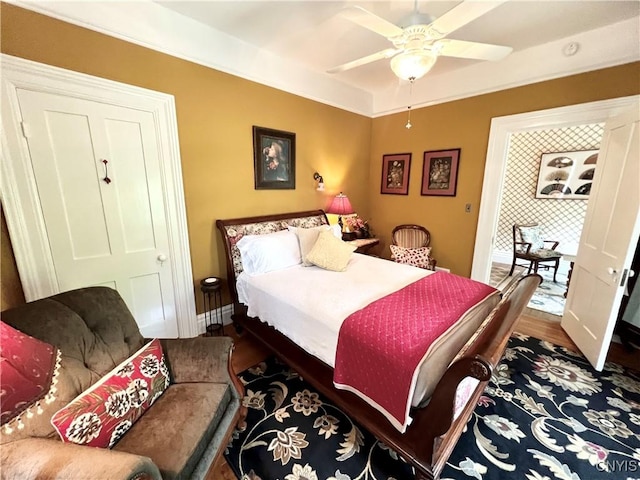 bedroom with wood finished floors, baseboards, and a ceiling fan
