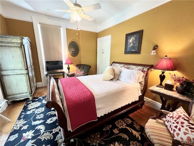 bedroom featuring baseboards, a ceiling fan, and wood finished floors
