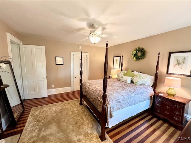 bedroom featuring ceiling fan, baseboards, and wood finished floors
